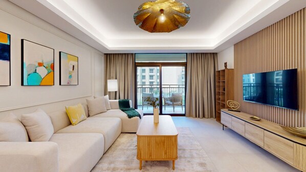 A modern living room with a sofa, a coffee table, a TV, and artwork on the wall. - Exquisite 1 Bed l near Souk Madinat l Burj Al Arab (Madinat Jumeirah Living)