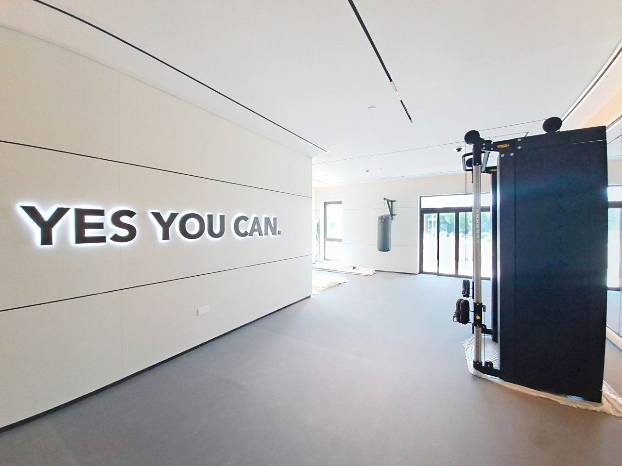 A gym with motivational wall text and exercise equipment.