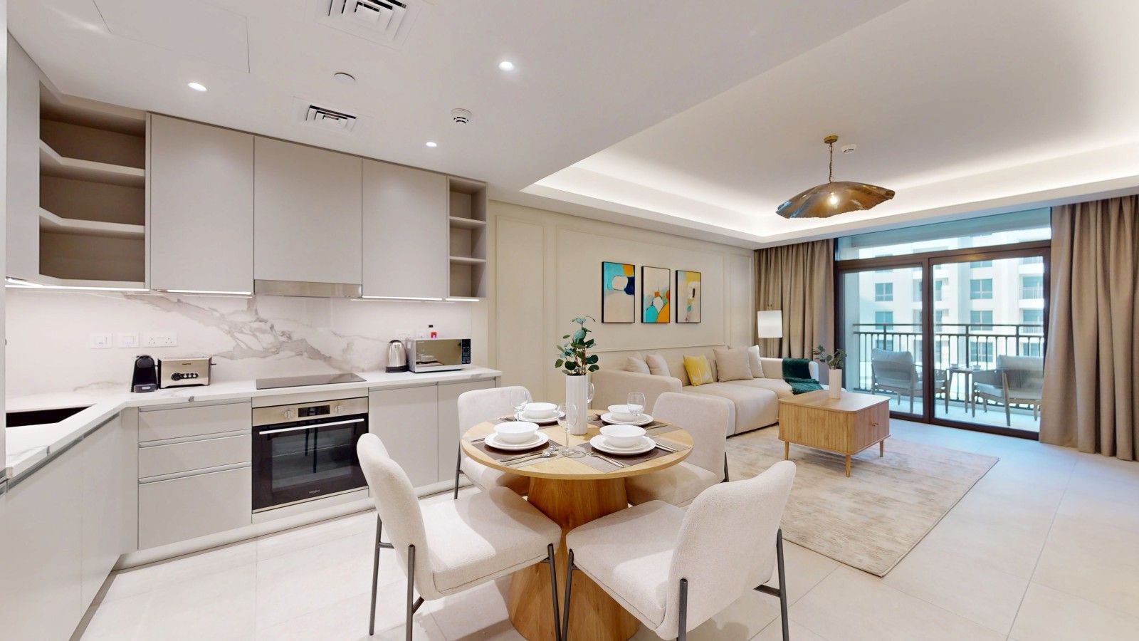 A modern living room with a dining area, a kitchen, and a balcony with a view.