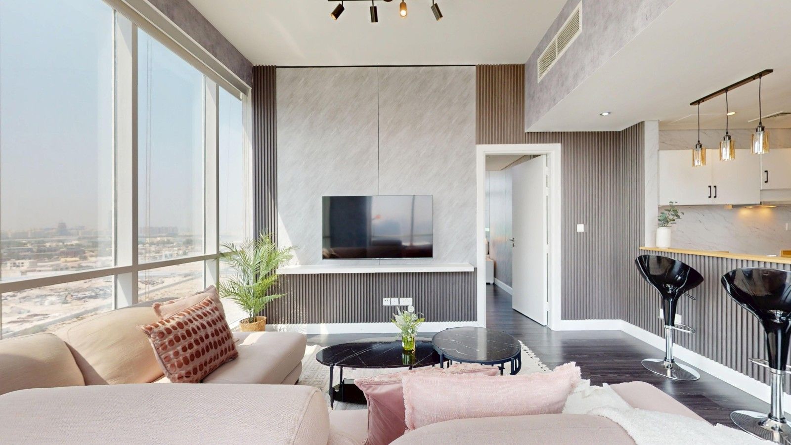 Un salon moderne avec un canapé, une table basse et un téléviseur fixé au mur.