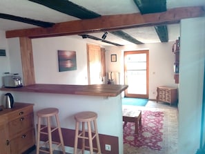 A kitchen with a wooden bar counter, two stools, a toaster, and a radiator. - New Listing (Trent)