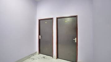 Dos puertas con los números 105 y 104, un suelo de baldosas y una pared lisa.