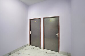 Dos puertas con los números 105 y 104, un suelo de baldosas y una pared lisa.