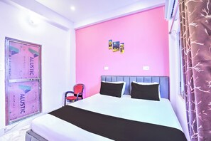 Une chambre à coucher avec un lit, une chaise et un mur décoré de posters.
