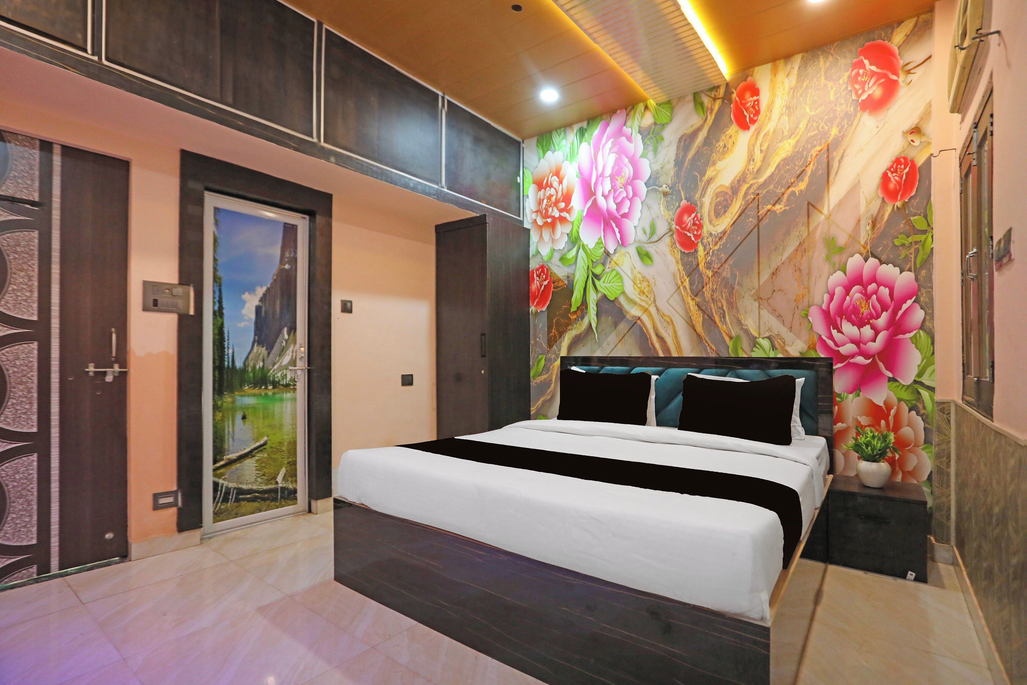 Un dormitorio moderno con una cama grande, una puerta con vistas panorámicas y una pared con estampado floral.
