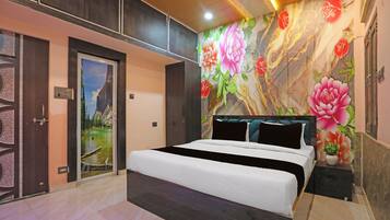 Un dormitorio moderno con una cama grande, una puerta con vistas panorámicas y una pared con estampado floral.