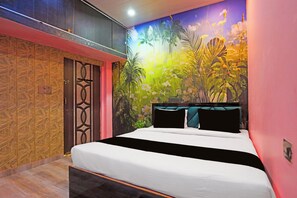 A bedroom with a bed, a mural, and patterned walls. - Hotel O by OYO The Baba Guest House (Varanasi)