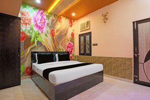 A bedroom with a bed, a wardrobe, a decorative wall, and a door. - Hotel O by OYO The Baba Guest House (Varanasi)