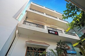 Un edificio de varios pisos con balcones, un letrero que dice 'OYO Hotel' y una fachada con azulejos.