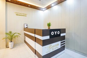 Un comptoir d’accueil avec une enseigne indiquant la présence d’un restaurant et d’une maison d’hôtes.