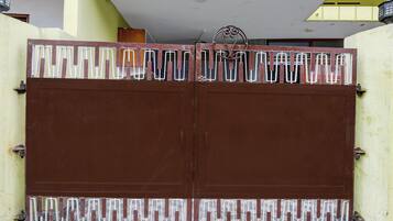 A brown metal gate with a decorative metal pattern.