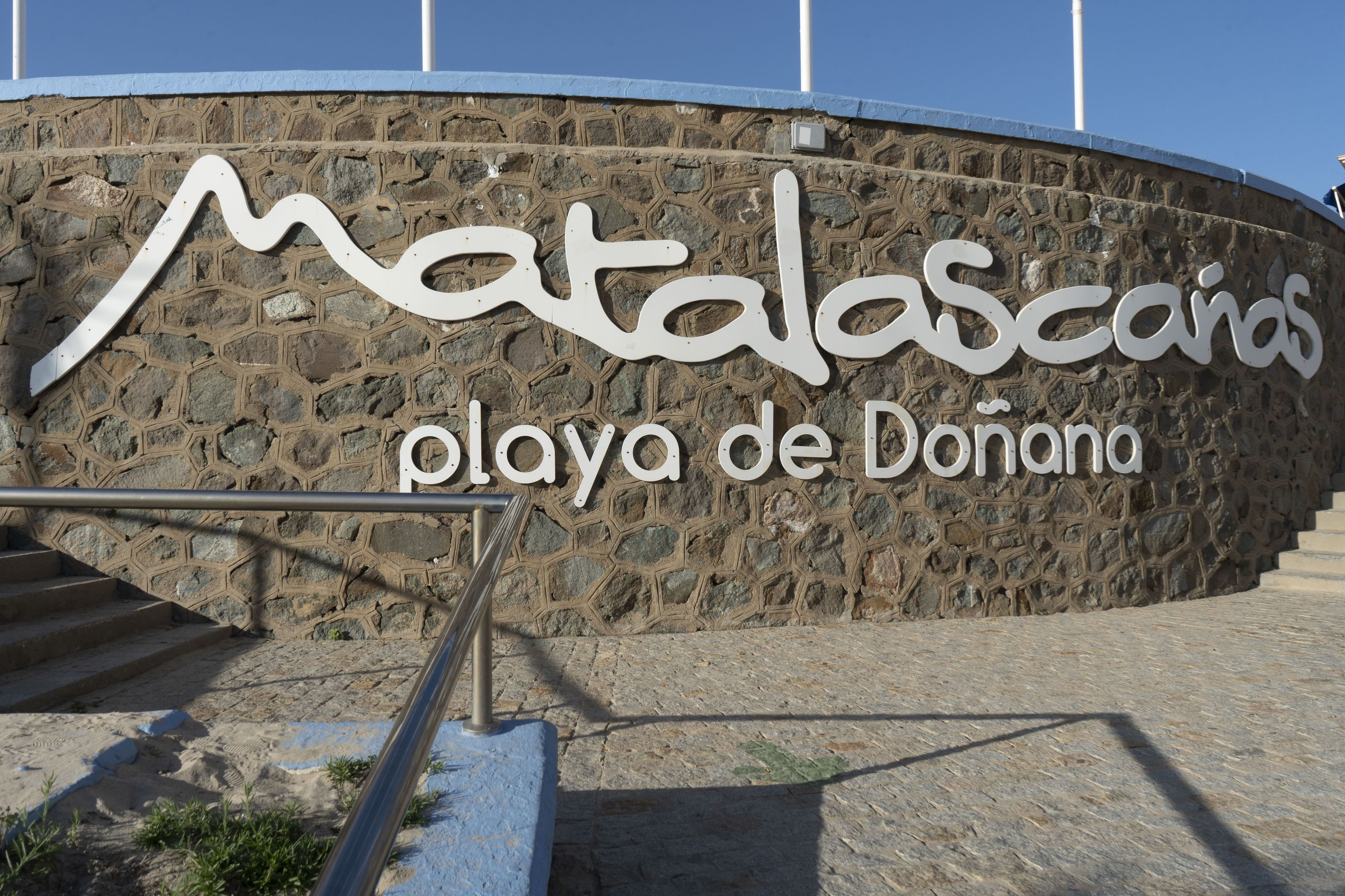 Un muro de piedra con el texto 'Matalascanes playa de Donana', indicando una ubicación o nombre de propiedad.