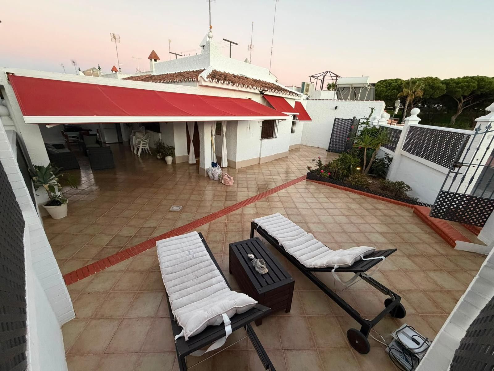 Terraza en la azotea con dos sillones de descanso, una mesita y un generador eléctrico.