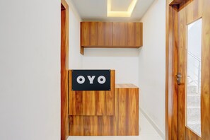 A reception desk with a sign reading 'OYO' in a modern interior with wooden accents. - Hotel O Natraj Paying guest house (Varanasi)