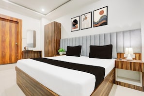 A modern hotel room with a large bed, wooden wardrobe, and a bedside table with a lamp. - Hotel O Natraj Paying guest house (Varanasi)