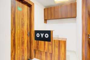A hotel room with wooden doors, a reception desk, and a sign that reads 'OYO'. - Hotel O Natraj Paying guest house (Varanasi)