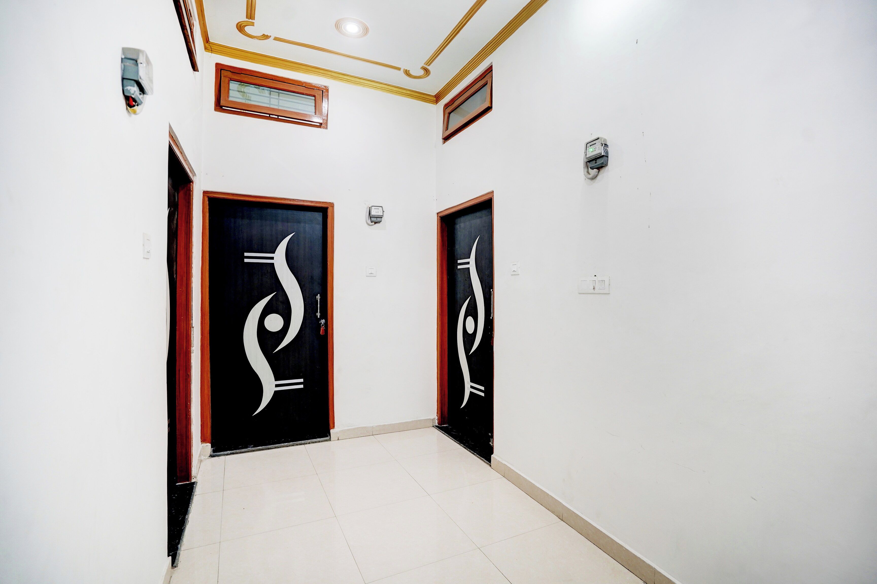 Un couloir avec deux portes, chacune ornée d’un motif noir et blanc original, qui donnent accès à des pièces.