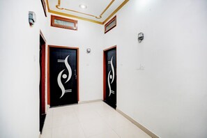 Un pasillo con dos puertas, cada una con un diseño blanco y negro distintivo, que dan a habitaciones.