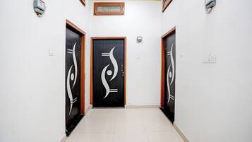 Un couloir avec trois portes, chacune ornée d’un motif abstrait original.