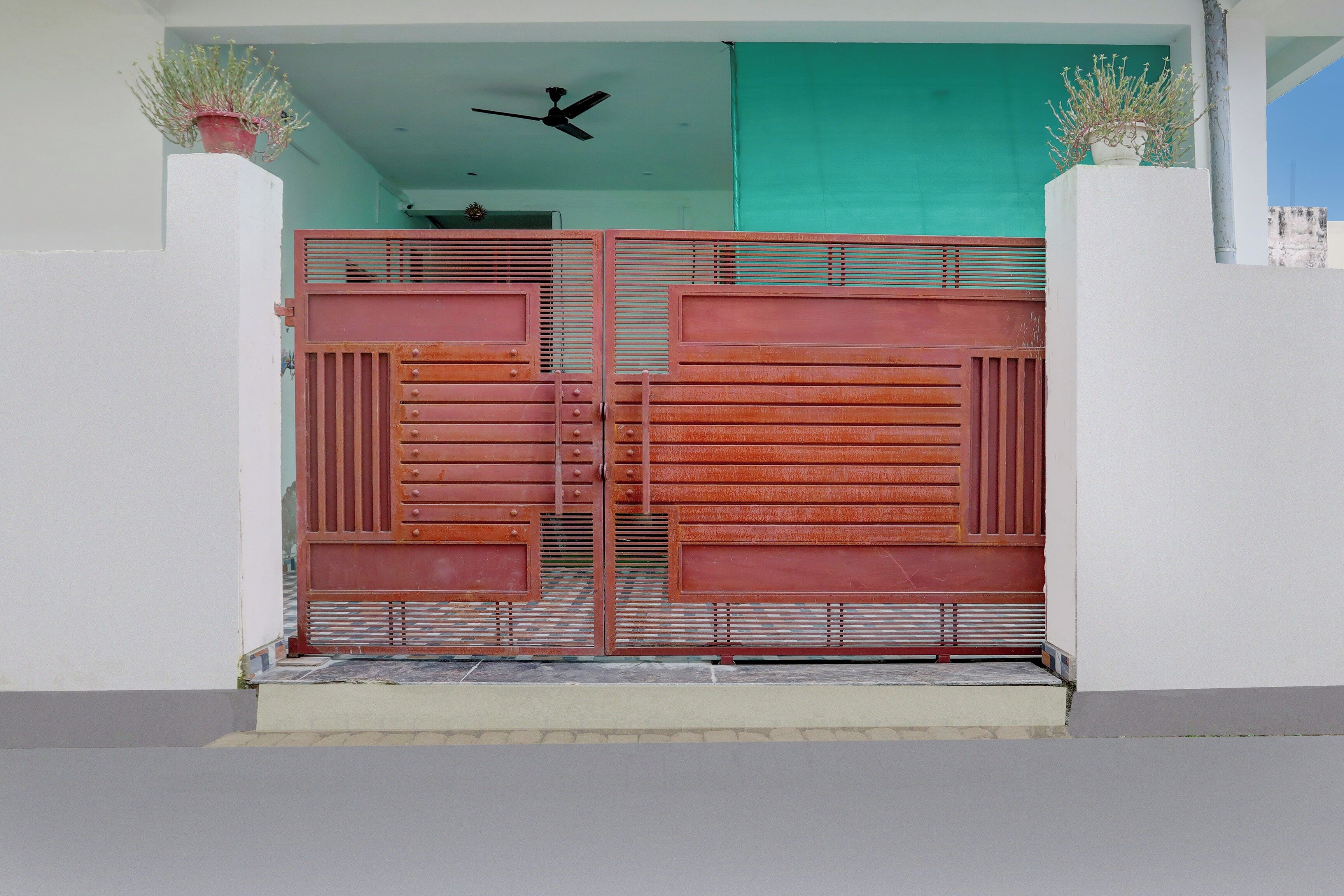 Una reja metálica con barras horizontales y un ventilador encima.