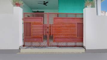 Una reja metálica con barras horizontales y un ventilador encima.