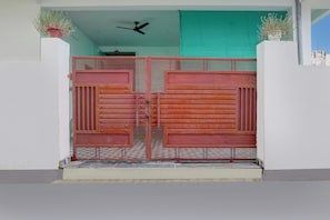 Una reja metálica con barras horizontales y un ventilador encima.