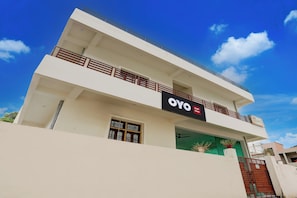 Un edificio de dos pisos con un letrero que dice 'OYO Kasai Home'.