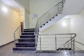 Una escalera con barandillas de metal y peldaños de mármol.