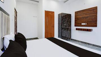 Une chambre d’hôtel avec un lit, une porte en bois et une grande œuvre d’art accrochée au mur.