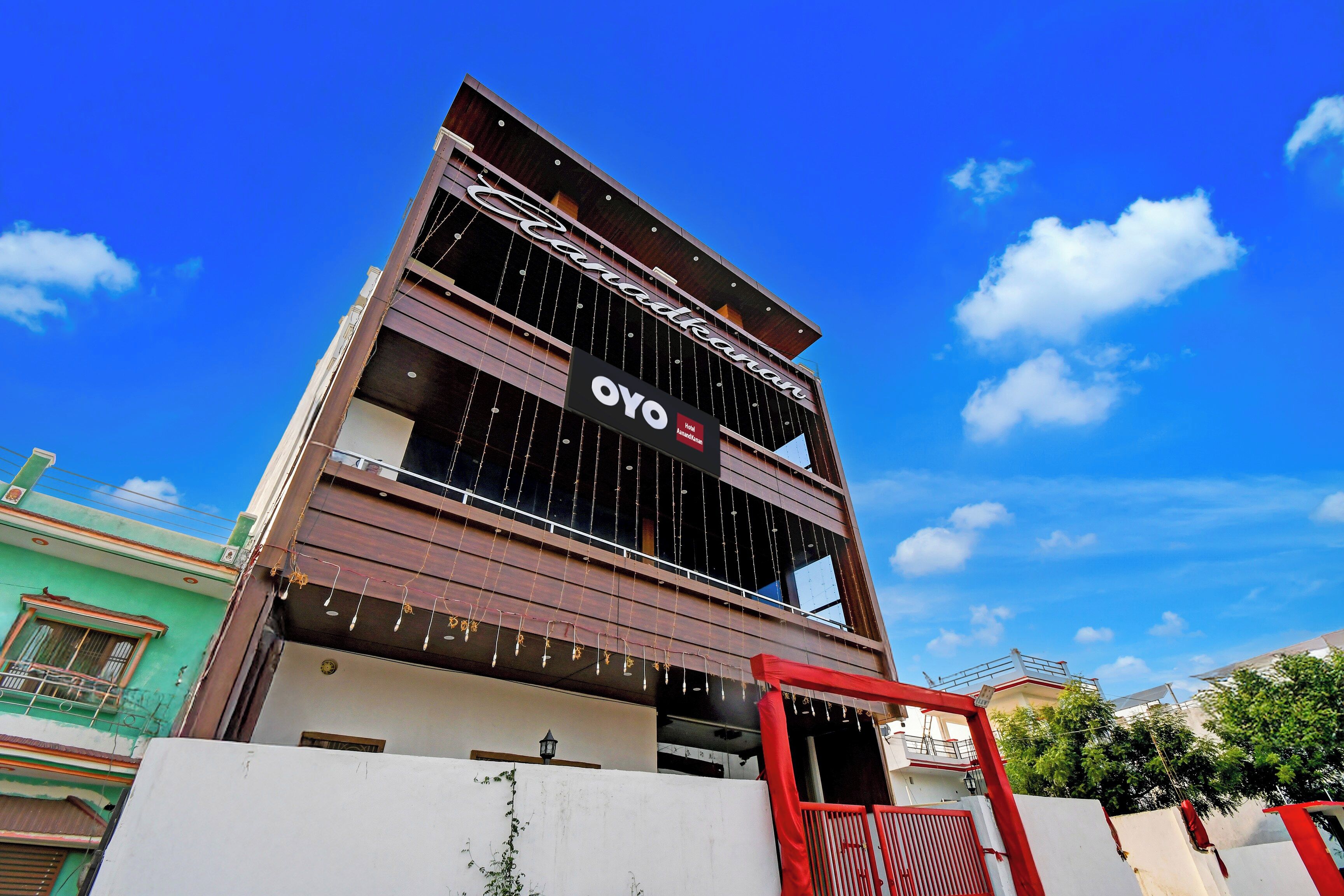Un hôtel au design moderne, avec une enseigne bien visible portant le nom « OYO » et un balcon doté d’une balustrade.