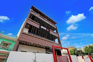 A hotel with a modern design, featuring a prominent sign with the name 'OYO' and a balcony with a railing. - Hotel O AanandKanan (Varanasi)
