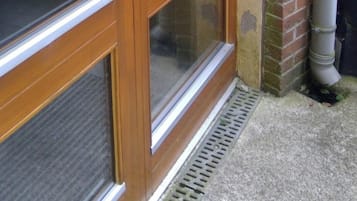 A wooden door with a glass panel, a metal handle, and a keypad lock.