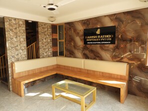 Um interior moderno com parede de pedra, um banco de madeira e uma mesa de vidro.