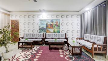 Ein Zimmer mit einer Wand mit Muster, einem großen Poster und einem roten Teppich.