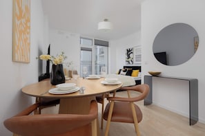 A modern dining area with a round table, chairs, and a vase with flowers. - Warszawa | Krochmalna 61 | Modern Studio | Air Conditioning (Warszawa)