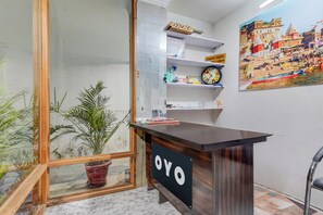 Un comptoir d’accueil avec une pancarte, une horloge et une étagère contenant divers objets.