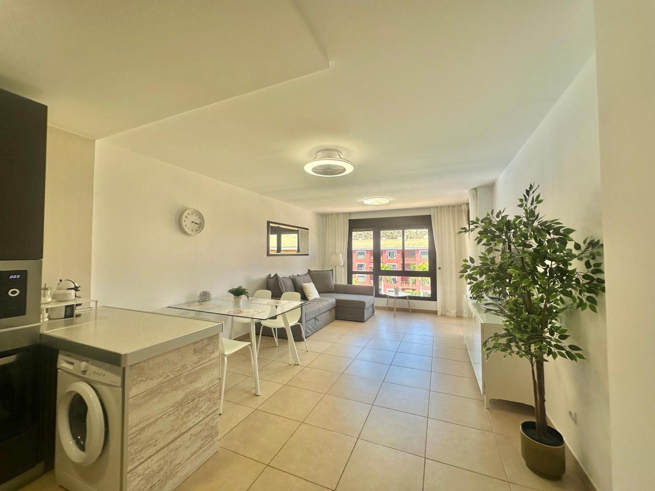 A modern apartment with a kitchen, dining area, and living room.