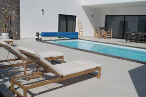 Un espace piscine équipé de chaises longues, d’un toboggan à eau bleu et d’une échelle.