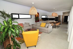 A modern living room with a sofa, armchairs, and a dining area with a table and chairs. - New Listing (La Oliva)