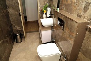 Une salle de bain moderne équipée de toilettes, d’un lavabo et d’une douche.