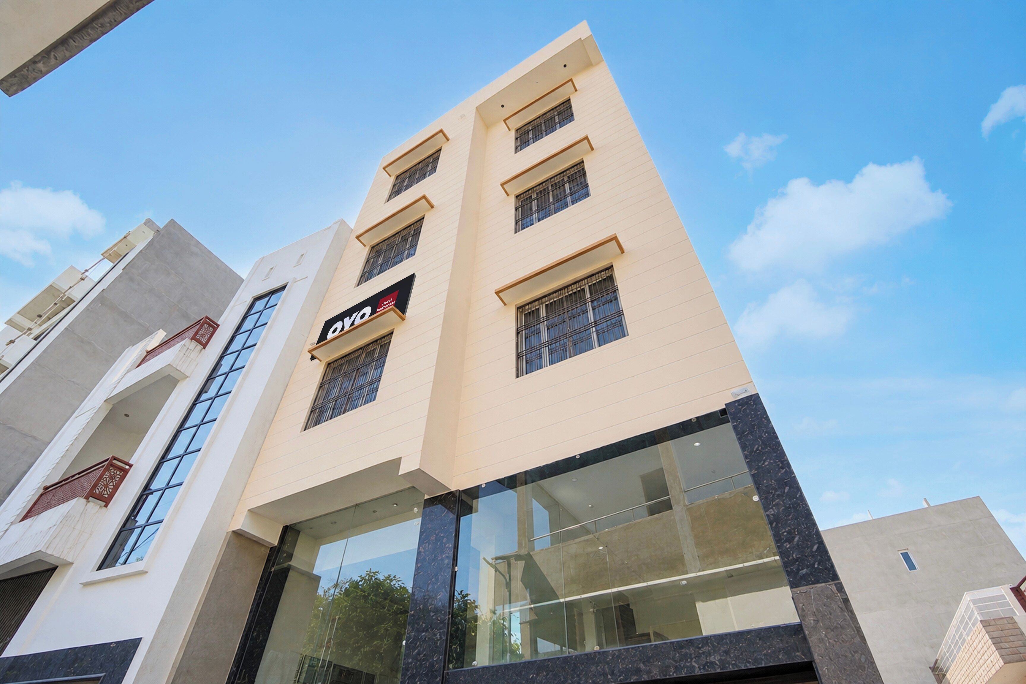 Un edificio de hotel de diseño moderno, con amplias ventanas y un cartel llamativo.