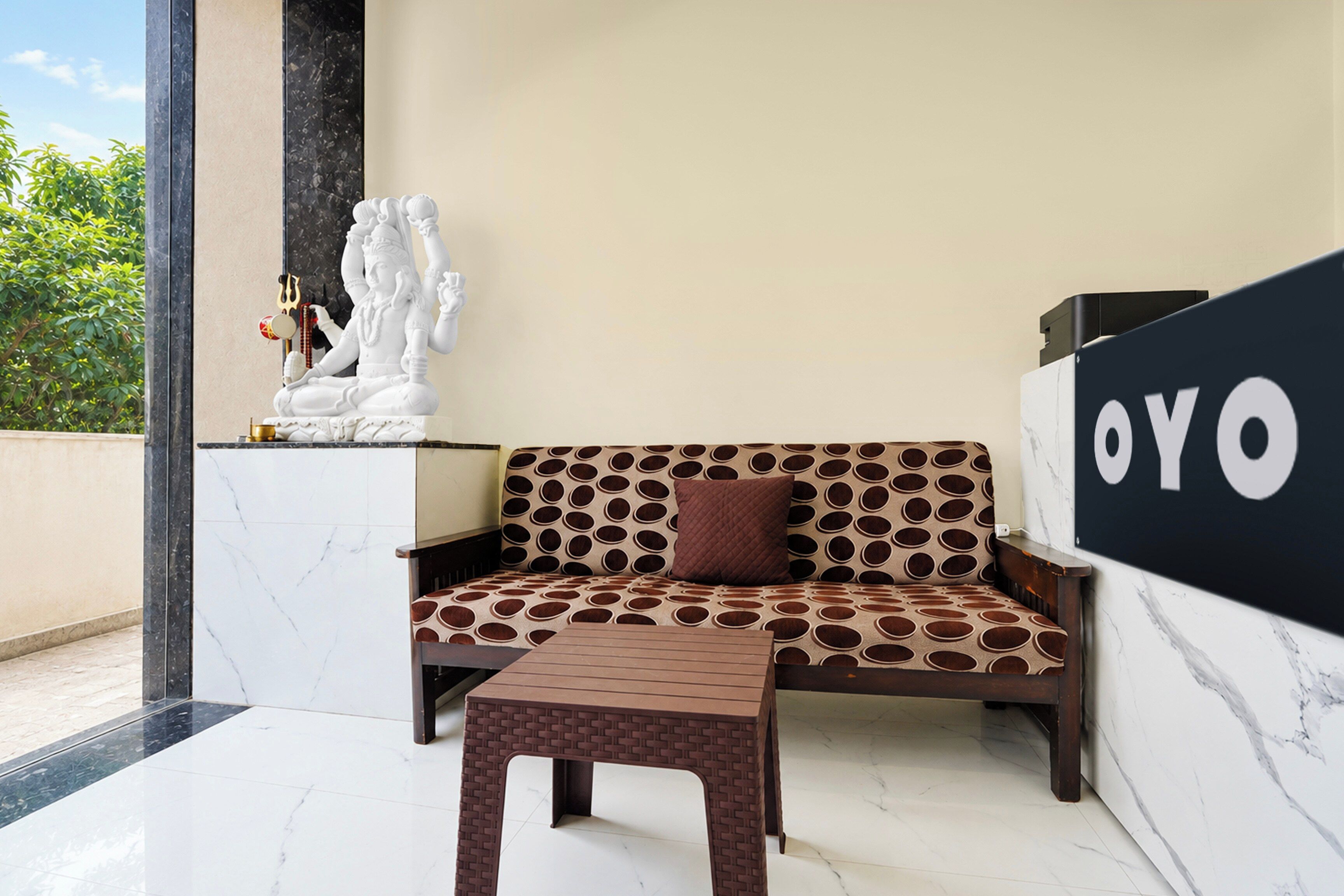 Una sala moderna con un sofá, una mesita y una estatua decorativa.