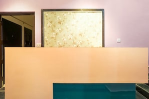 Una habitación con un ventanal grande, una puerta y una lámpara fijada a la pared.