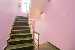 Una escalera con barandilla metálica que conduce a un rellano.