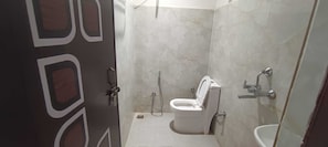 Un baño con inodoro, bidé y lavamanos.