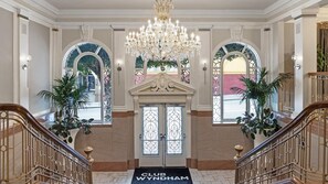 Imponente entrada con candelabro, puerta doble y un felpudo con la leyenda 'CLUB WYNDHAM'.