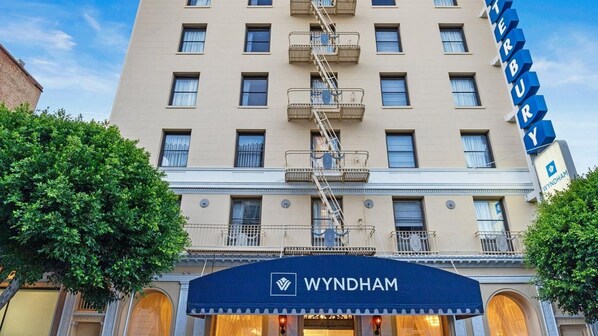 Un edificio de hotel con un letrero que dice 'WYNDHAM' y una escalera de emergencia.
