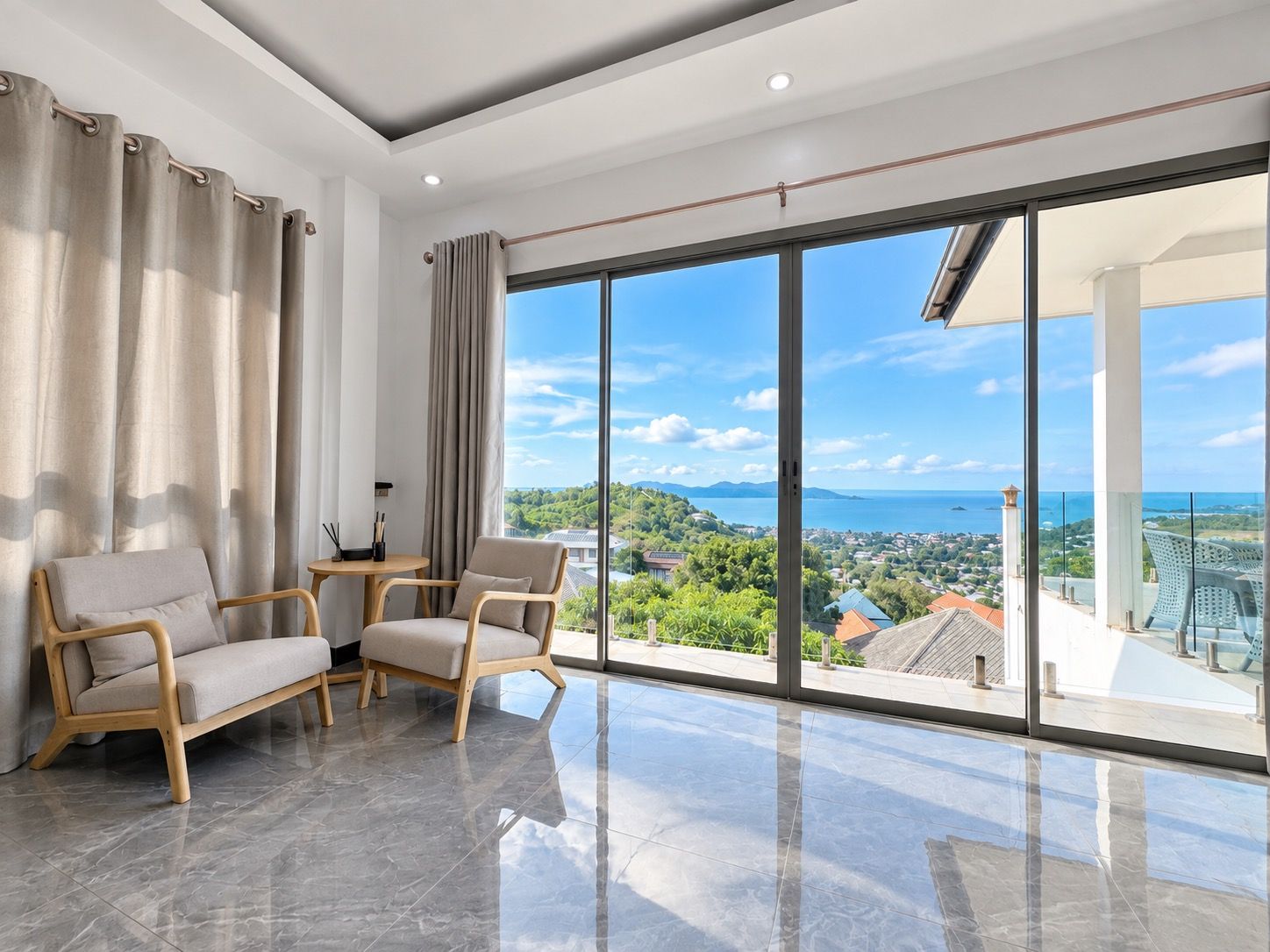 Een moderne woonkamer met een grote schuifpui die uitkomt op een balkon met uitzicht op de stad.