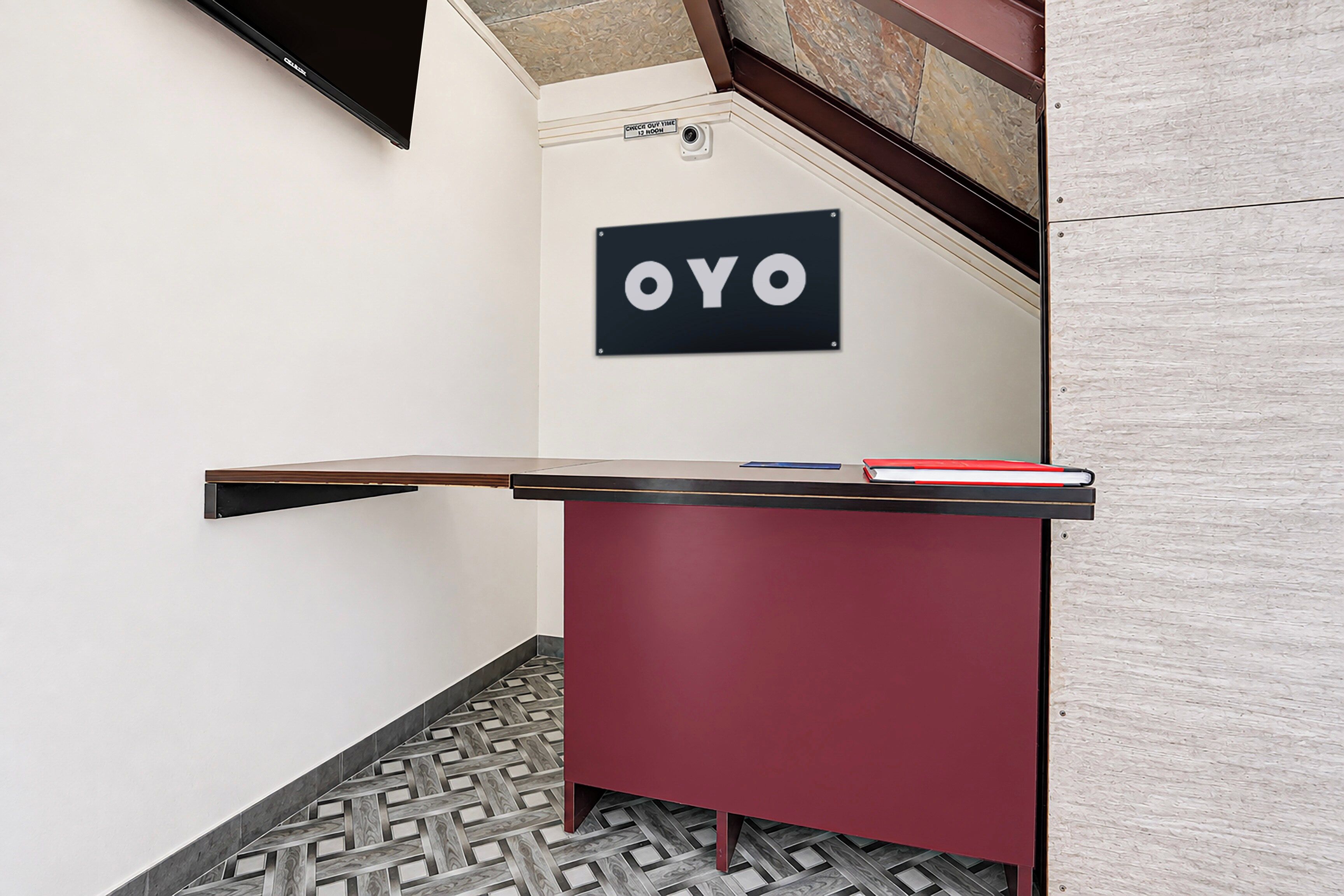 Un comptoir d'accueil avec une enseigne indiquant « OYO » dans le hall d'un hôtel.