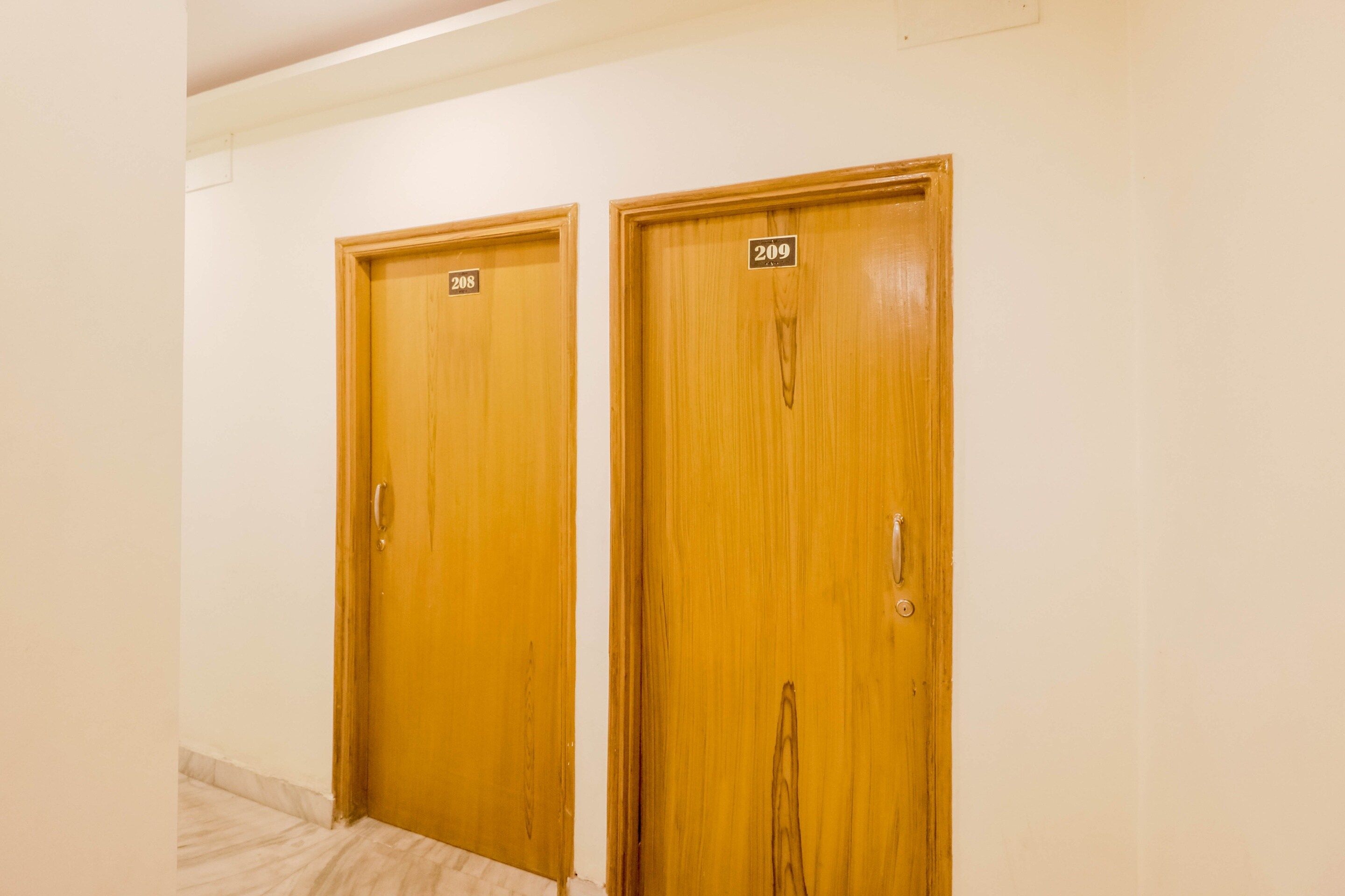 Dos puertas de madera con los números 208 y 209, indicando los números de habitaciones de un hotel.